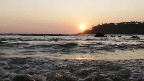 Waves on sea reaching on shore during sunset Stock Footage 71564131