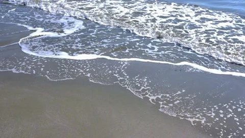 The waves of the sea roll over the sandy shore of the beach slowly Video stock 144586840