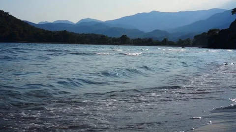 Waves of the sea on a sandy beach with mountains in the background. Stock Footage 108078774