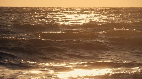 Waves at sea at sunset. In slow motion against an orange sun Stock Footage 107855457