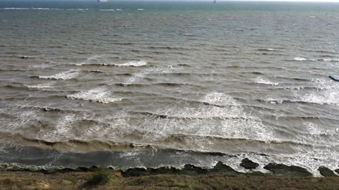 Waves on seashore in sunny weather. Cloudy water, top view. Stock Footage 153589508