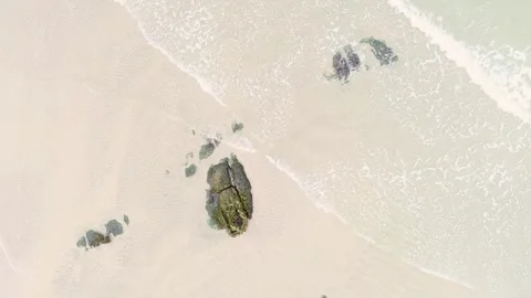 Waves on the shore of a beach with some rocks, top view from a drone. Backg.. 스톡 동영상 293009516