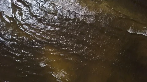 Waves on the shore of a sandy beach in the sun. shooting from the air above. Video stock 92841293