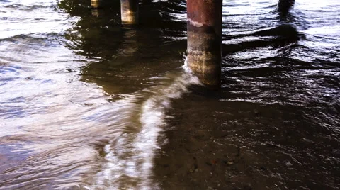 Waves on shore touching columns of bridge. Stock Footage 60171513