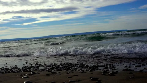 Waves on a shoreline coming in over smaller stones Stock Footage 144903320