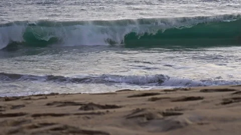 Waves in slow motion with the beach out of focus in the foreground Stock Footage 266435998