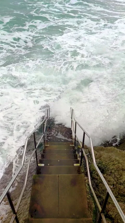 Waves in slow motion break against the stairs Video stock 259759785