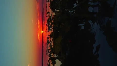 Waves slowly float towards the shore with turquoise red and pink sunset sun and Stock Footage 256993774