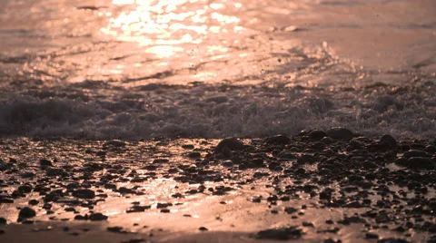 Waves slowly splashing on the sand at sunset Stock-Footage 68734121