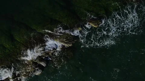 Waves slowly wash over a rocky ridge in the ocean at night, aerial view. Stock Footage 160842828