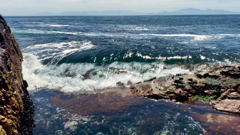 Waves slowly washing over rocks and a rockpool Stock Footage 170141319