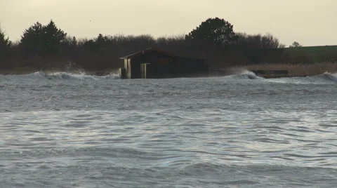 Waves smashing in to a beach house while seagulls hanging low over the waves Stock Footage 45422622