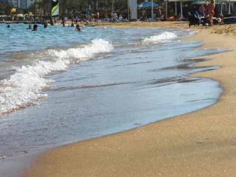 Waves smoothly envelop the sandy shore Stock-Fotos
