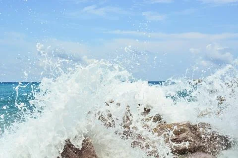 Waves splash against rocks on beach Stock Photos