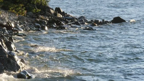 Waves splash against the rocky shore of the lake. Stock Footage 290116282