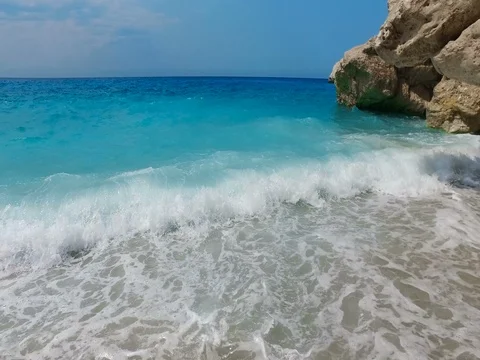 Waves splash crashing on the rocks and sandy shore on Kathisma Beach, Greece Stock Footage 80052956