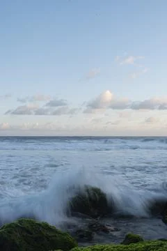 Waves splash on mossy rocks Stock Photos