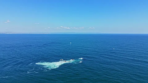 Waves splash in the ocean under a bright blue sky with distant land in the Stock Footage 344816650