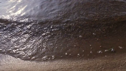 Waves splash on the sandy bank of the river close up. Stock Footage 128165827