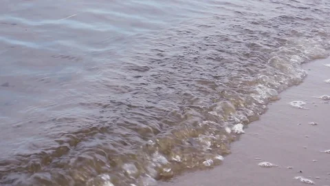 Waves splash on the sandy bank of the river close up. Stock Footage 128165855