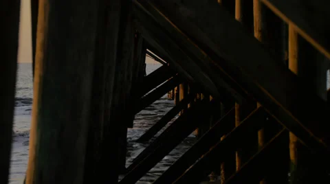 Waves Splash Under Pier at Sunrise Stock Footage 68778812