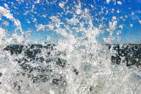 Waves splashed close-up, beautiful clear wave drops against the sky, backgrou Stock Photos
