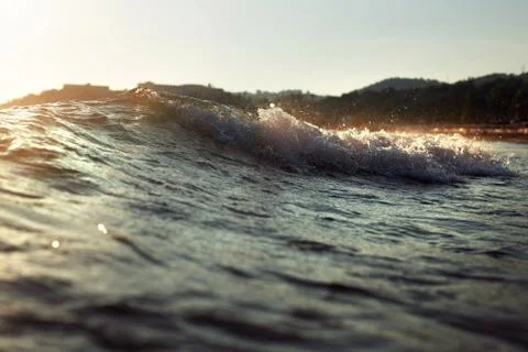 Waves with splashes and highlights of the setting sun, beautiful and bright n Stock Photos