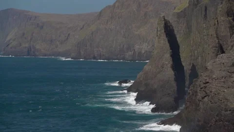 Waves Splashing on Geitaskoradrangur sea stack Leitisvatn on Vágar. Slomo Stock Footage 194435134