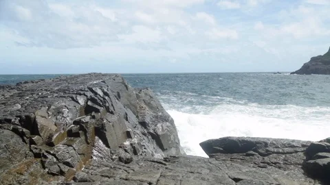 Waves splashing on the rock during storm weather. Clouds, blue sky. Stock Footage 103468887