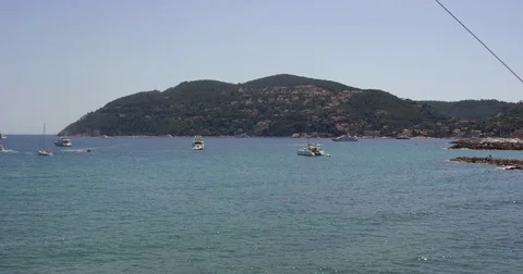 Waves splashing at rock stone at seashore coast with luxurious yachts in sea bay Stock Footage 78693366