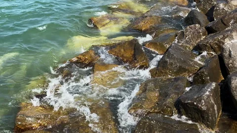 Waves splashing on the rocks of a break wall in summer Video stock 343571317