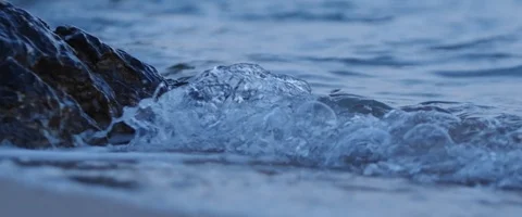 Waves splashing on rocks at night in slowmotion, blue hour in the evening Stock Footage 97899883
