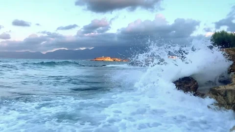 Waves splashing on rocks in sea ocean shore with mountains nature landscape on Stock Footage 333399548