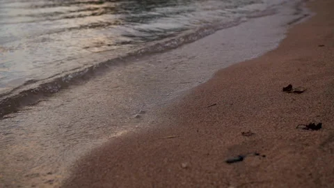 Waves splashing onto sandy beach during sunset Stock-Footage 146766608