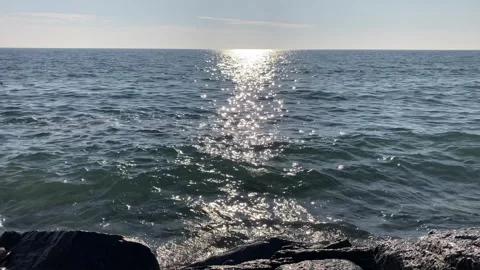 Waves splashing at shore while sun is sparkling in the water Stock Footage 265823475