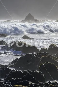 Waves splashing as they break close to shore and rugged rocks along the South co Stock Photos