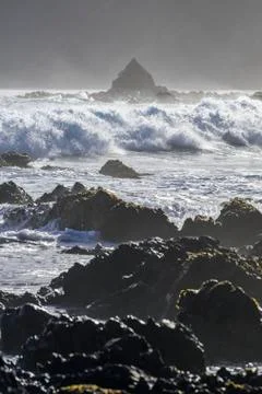 Waves splashing as they break close to shore and rugged rocks along the South co Stock Photos