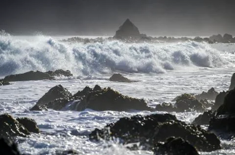 Waves splashing as they break close to shore and rugged rocks along the South co Stock Photos
