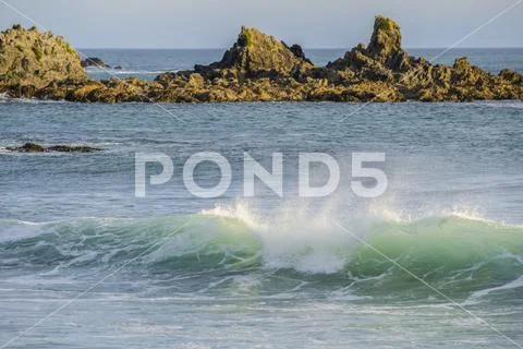 Waves splashing as they break close to shore and rugged rocks along the South co Stock Photos