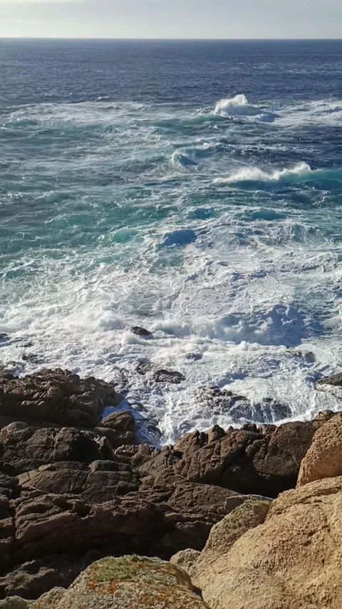 Waves of a stormy sea with foam break on stone coastal rocks Stock Footage 236644582
