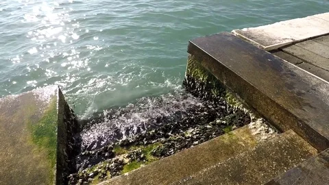 Waves strike steps in the sea, green mold, quay in Venice, Italy Stock Footage 75037078