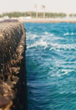 The waves strike the stone pier in blurring Stock Photos