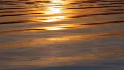 Waves at sunset; reflection of the sun on the sea Stock Photos