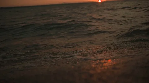 Waves at sunset in slow-motion, pan down from sky to water at 29,97 fps Stock Footage 84995011
