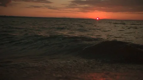 Waves at sunset in slow-motion, pan up from water to sky at 29,97 fps Vídeos de archivo 84995581