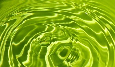 Waves on a surface of green water. Stock Photos