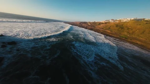 Waves surge against cliffs at sunrise Stock Footage 339788289