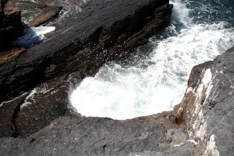 Waves that swell on the rocky e Stock Photos