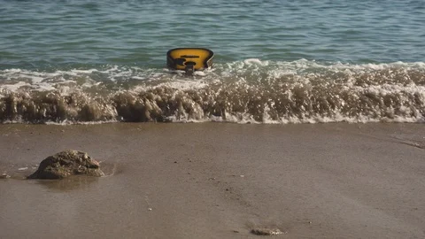Waves throw guitar ashore or empty sandy wild beach. Tide brings the guitar Stock-Footage 126964077