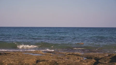 Waves throw guitar on empty shore or stone beach. Tide brings the guitar ashore Video stock 126956475